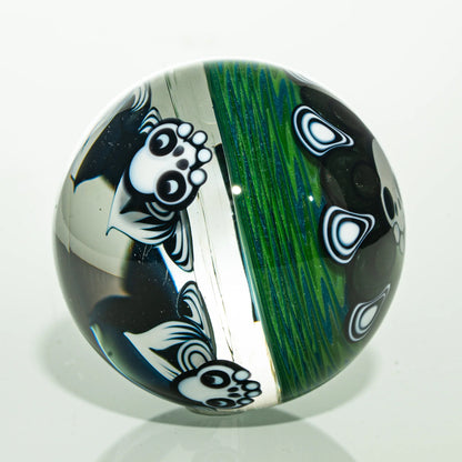 Handmade glass marble featuring panda designs and vibrant green linework on clear background