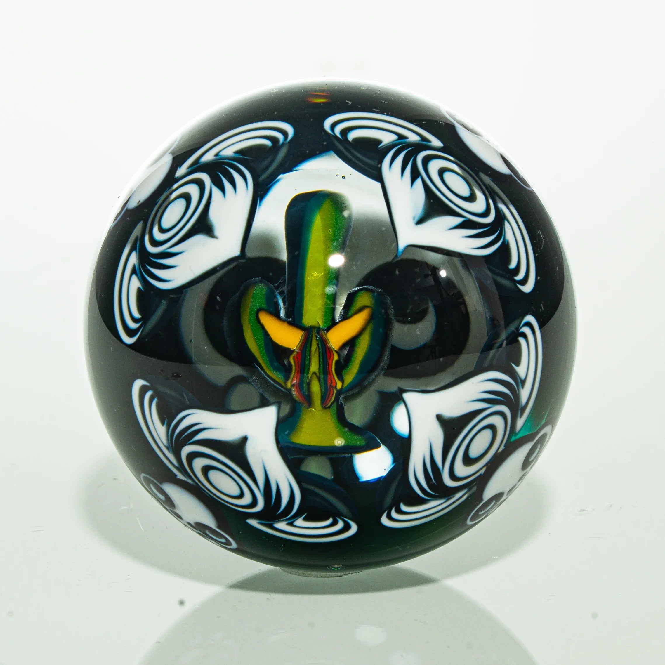 Handmade glass marble with intricate white swirl patterns and colorful floral design inside