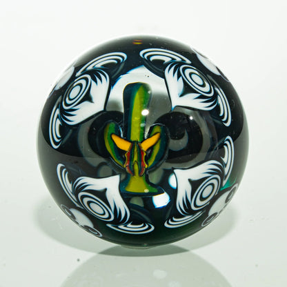 Handmade glass marble with intricate white swirl patterns and colorful floral design inside