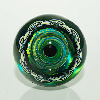 Colorful artisan glass marble with black and white chain design and iridescent center