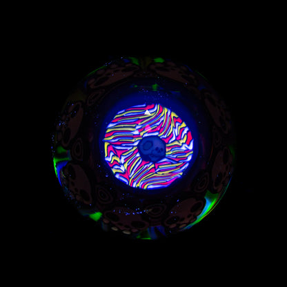 UV reactive glass marble with psychedelic skull design and vibrant neon colors