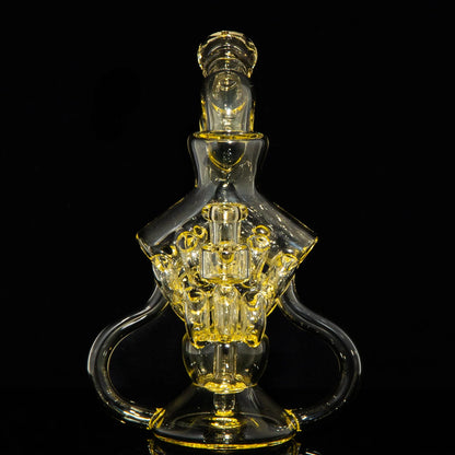 Intricate yellow-tinted glass water pipe with artistic design on black background