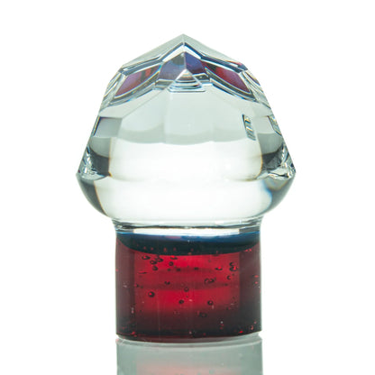 Clear glass carb cap with faceted top and red base, dab rig accessory on white background