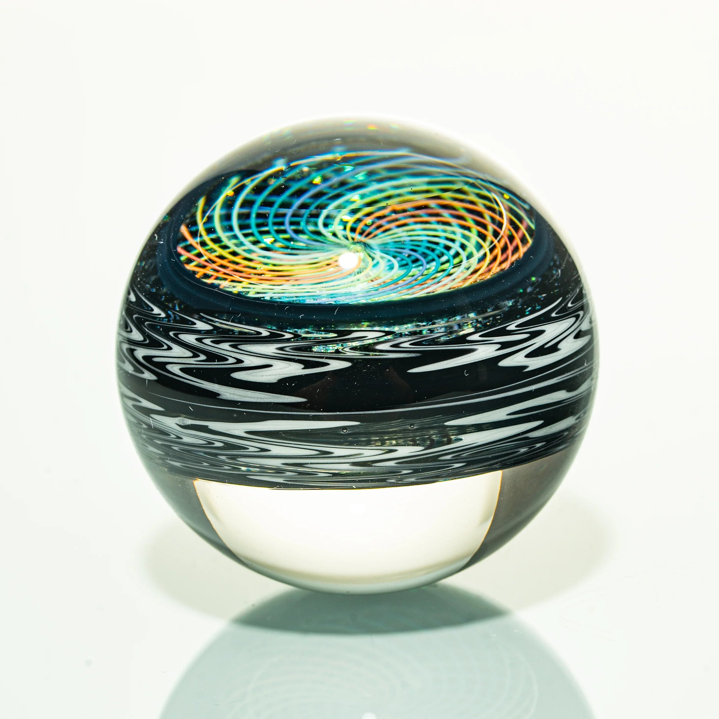 Colorful heady glass marble with spiral vortex design and intricate patterns on white background