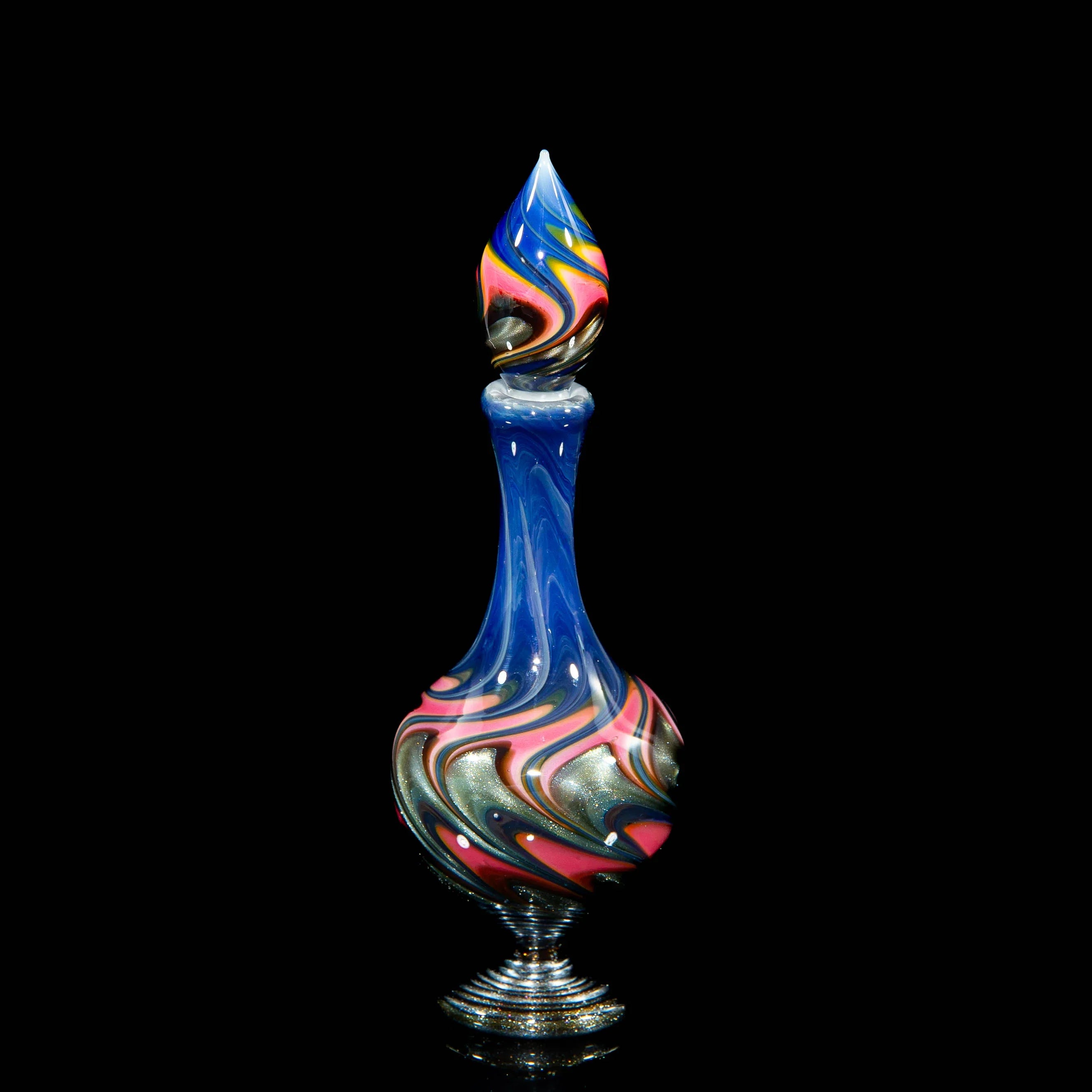 Colorful hand-blown glass art piece with swirled blue, red, and gold patterns on black background