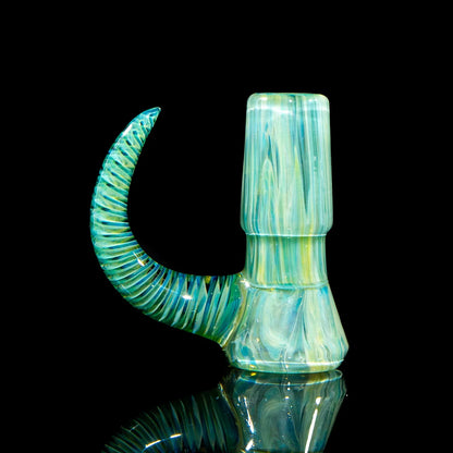 Handcrafted blue and green glass slide with spiral horn, displayed on a reflective black surface.