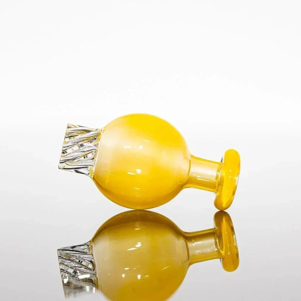 Yellow glass pipe with clear textured mouthpiece, reflective surface