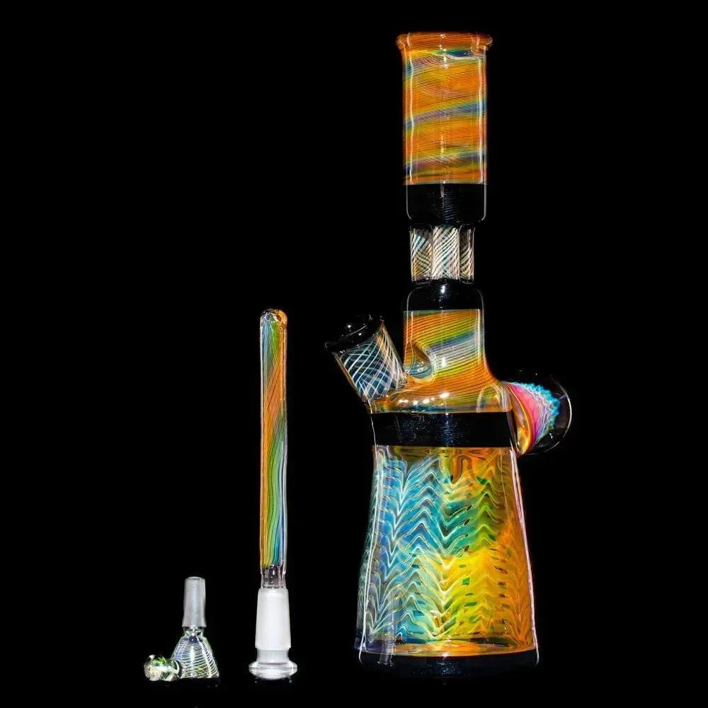 Colorful glass water pipe with triple pillar perc, slide, and removable downstem on black background