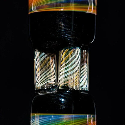Close-up of glass triple pillar perc tube with colorful swirled accents and black background