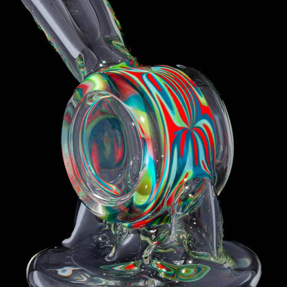 Close-up of a colorful heady glass water pipe with vibrant red, blue, and yellow patterns