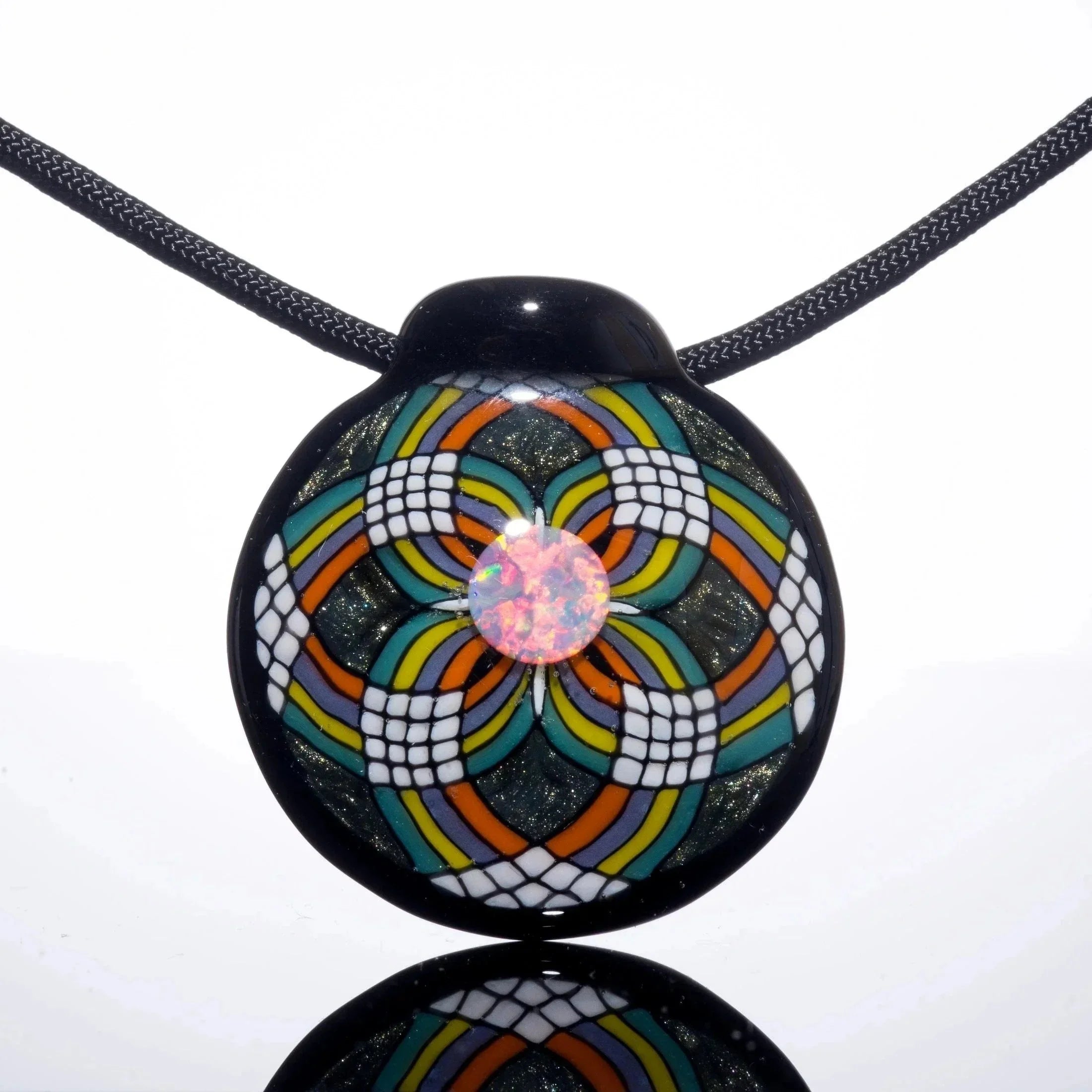 Colorful glass pendant with teal, orange, and yellow geometric pattern and opal center