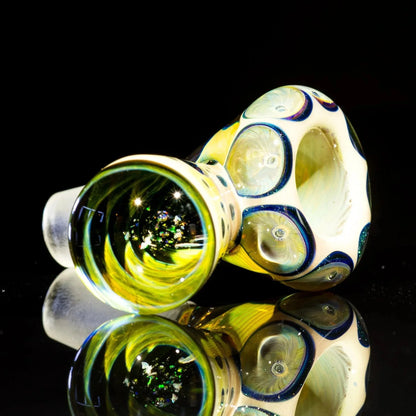 Heady glass bowl slide with carved caramel vortex and air trap design on black reflective surface