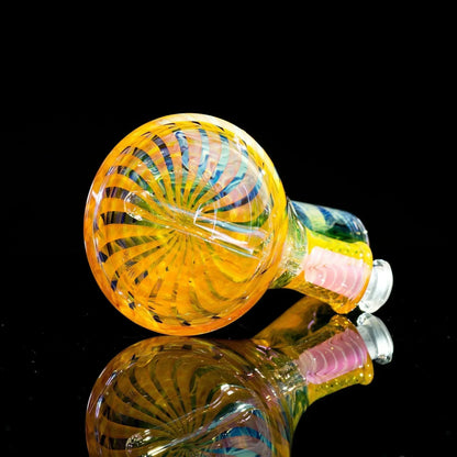 Vibrant heady glass pipe with swirling yellow, blue, and pink patterns, displayed on reflective black surface.