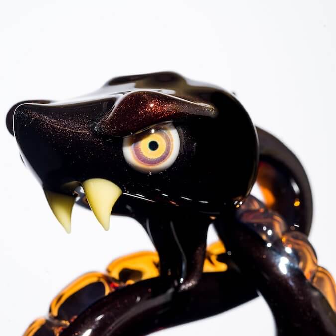 product shot eye of glass snake made by Niko Cray in Pomegranate over steel wool and tangjello