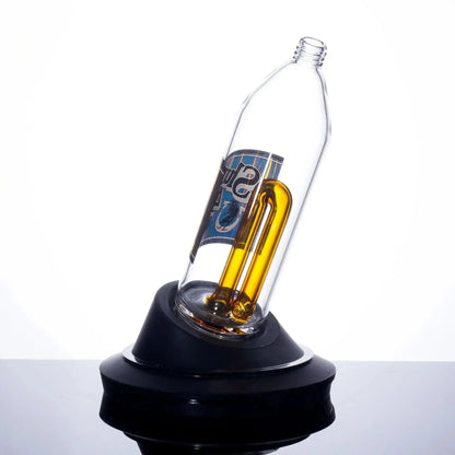 Clear glass bong with amber U-shaped tube and blue logo, displayed on black base
