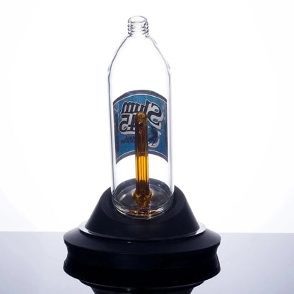 Clear glass bong with amber stem and blue label, displayed on black base