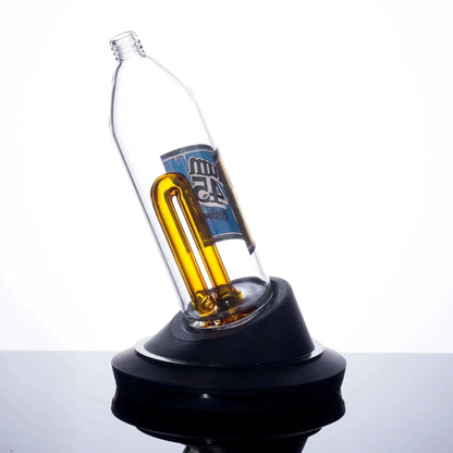 Clear glass bottle bong with amber U-shaped tube and blue label, displayed on black base