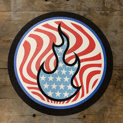 Stoked 17 inch circular mood mat on wood background with stoked flame logo in blue and white stars, background red wavy lines