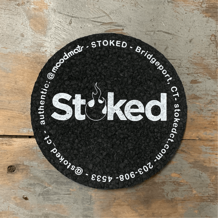 Stoked 5 inch coaster mood mat, black circular mat with Stoked logo in the center; written along circular edge is Stoked, Bridgeport CT, stokedct.com, 203-908-4533, @stoked_ct, @moodmats