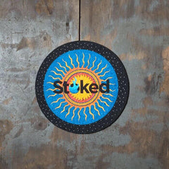 Stoked 8 inch mood mat on wood background. Blue and yellow sun logo centered