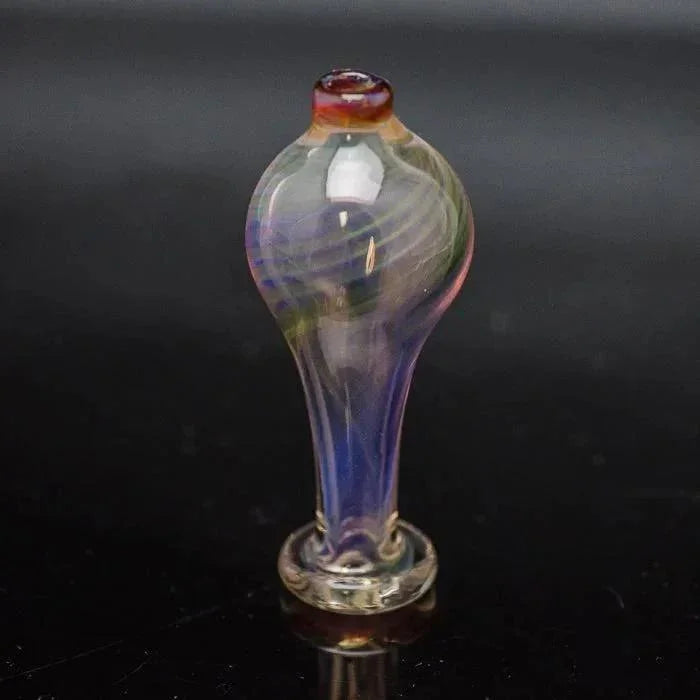 Iridescent glass bubble cap for dab rig on black background, detailed color swirls.